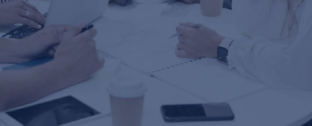Technology professionals reviewing project plans around a conference table